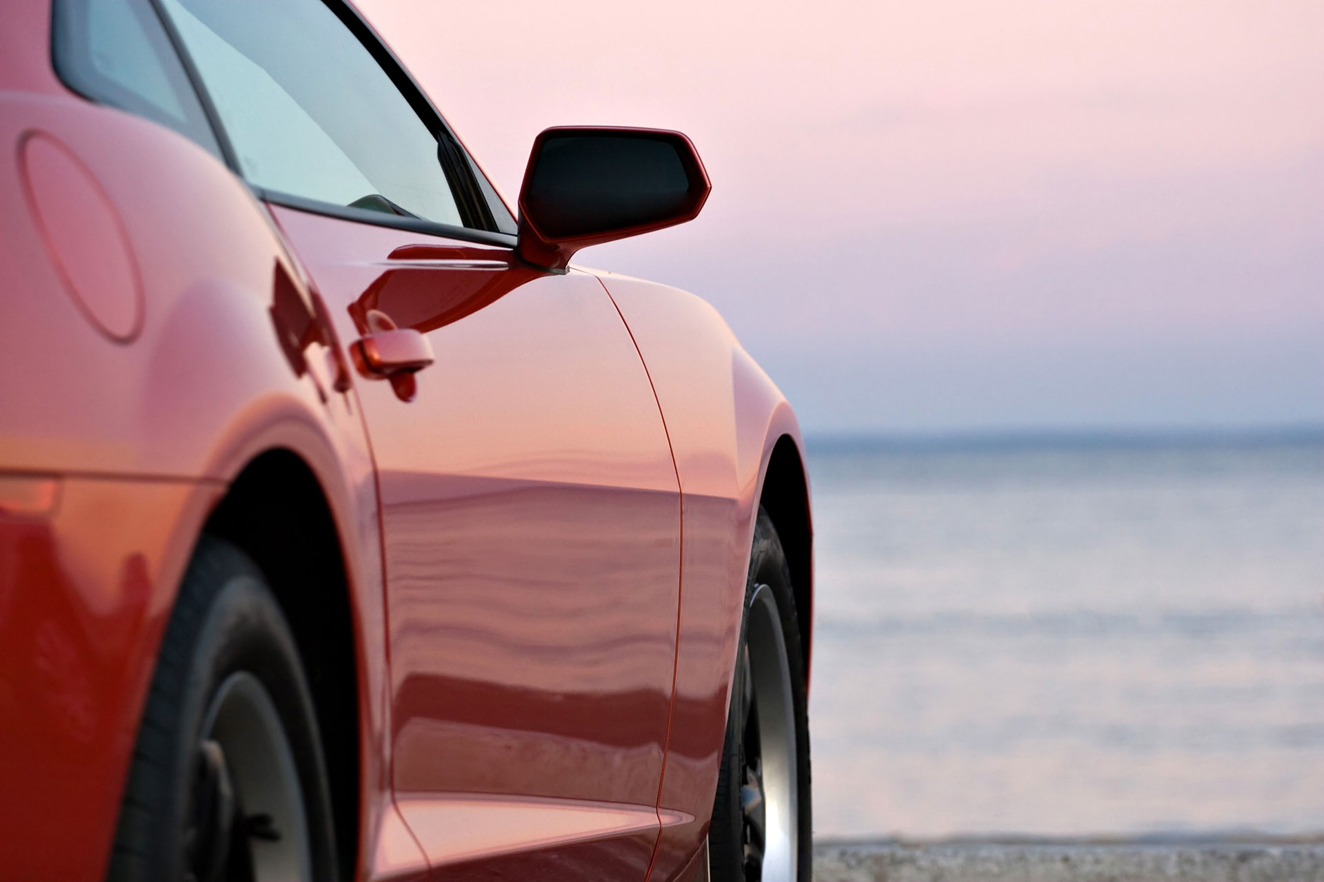 image of red car at beach