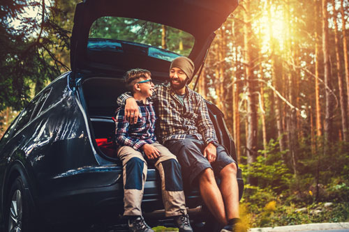 Father and son by their car hiking